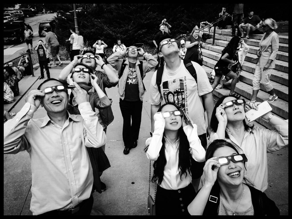 Group of men and women watching solar eclipse